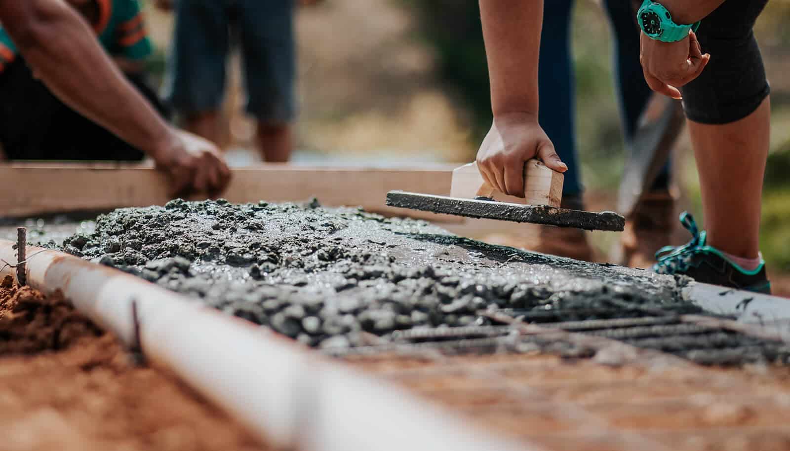 General contractor team flattening cement in a construction site of a welding manpower company