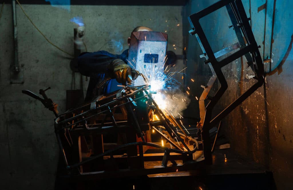 Fabrication Services welder with protective mask using gas welding